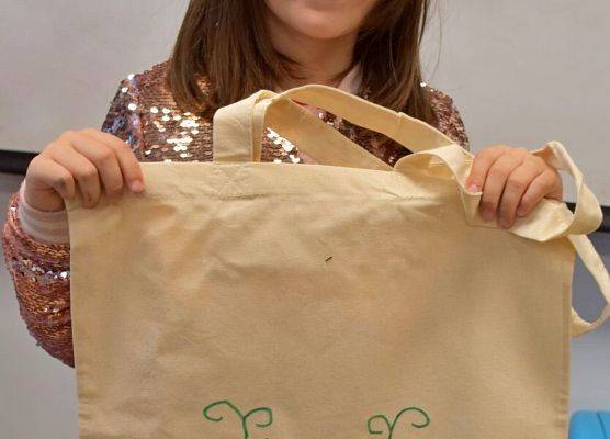 Dziewczynka prezentuje udekorowaną torbę