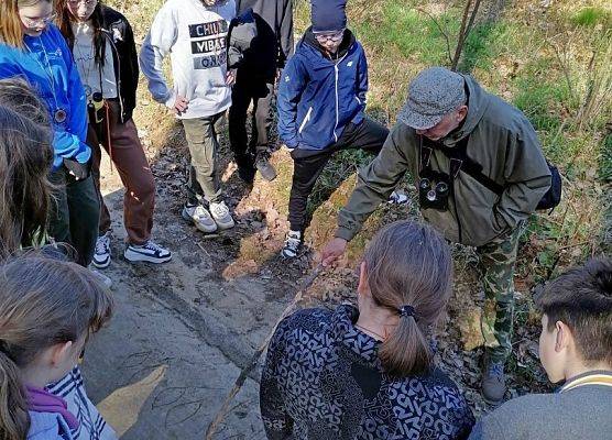 Grupa uczniów w lesie - rozpoznawanie tropów sarny i dzika. (Fot. SP w Leśniewie)