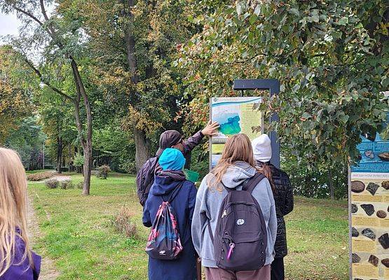 Jaką część Polski pokrywał lądolód? Uczniowie przy jednej z tablic edukacyjnych znajdujących się w  parku.