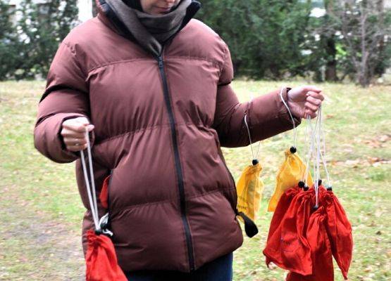 Pani ornitolog trzyma w rękach woreczki z ptakami i wraca do ośrodka