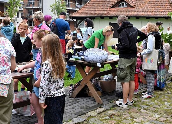 Nadmorski Piknik z Parkiem-stoiska edukacyjne przy siedzibie .NPK Widać Ok 6 stoisk. Przy każdym stoisku znajduje się kilka uczestników Pikniku oraz edukator.