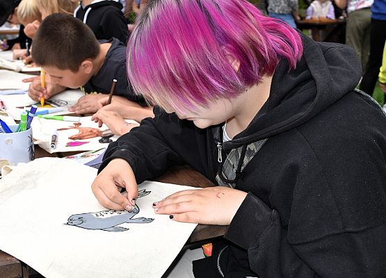 Przyrodniczy kąciki plastyczny Na pierwszym planie dziewczyna rysuje fokę szarą na torbie płóciennej