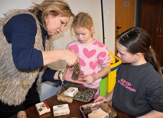 Uczesticy przygotowują szyszki tłuszczowe z nasionami