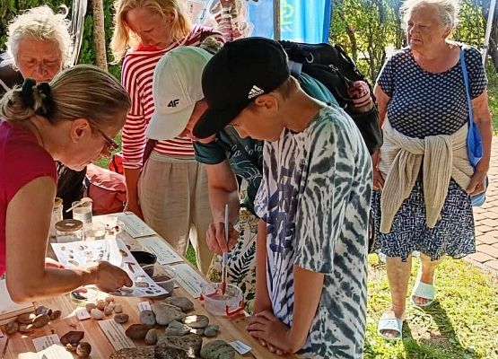 Kilka osób przy stoisku edukacyjnym Błekitnej Szkoły